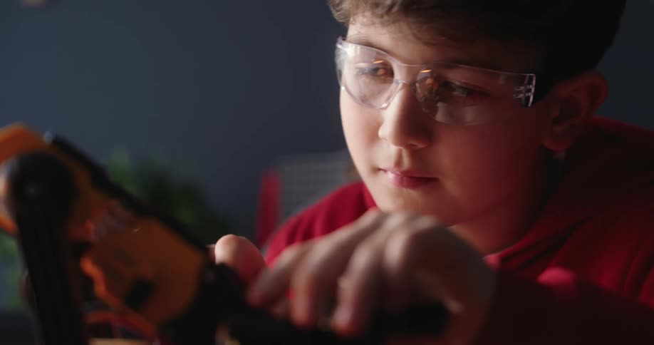 Portrait of a concentrated boy working with mechatronics