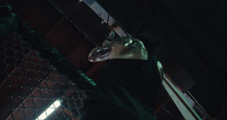 The woman grabs the rings above her head and does pull ups