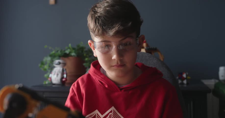 A boy watches the robotic arm work