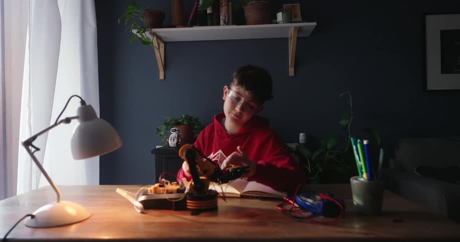 A footage of a boy working on a robotic project