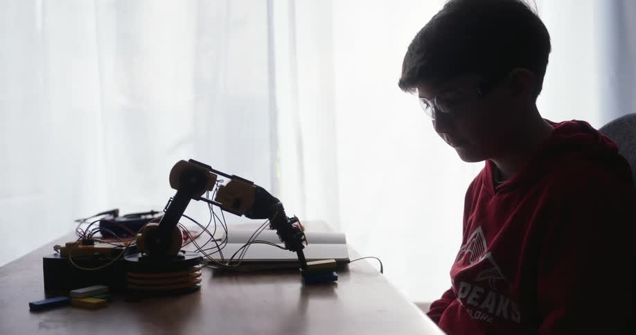 A footage of a boy watching a robotic toy work