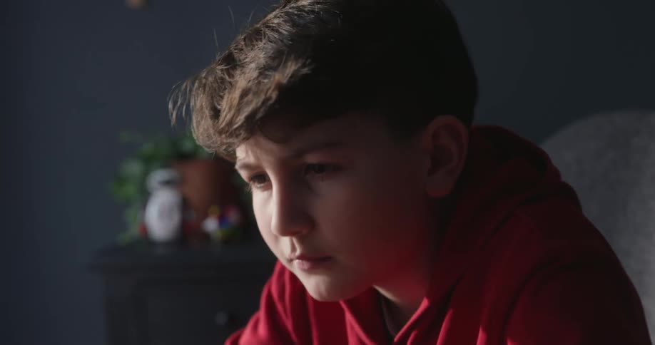 Boy with confident facial expression typing on a laptop