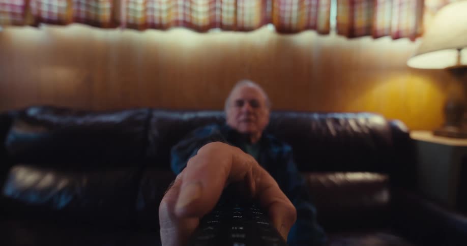 A man is pointing the remote and pressing the buttons