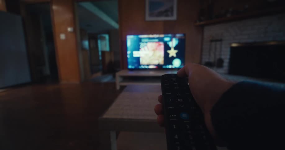 A man lifts the remote and turns off the television
