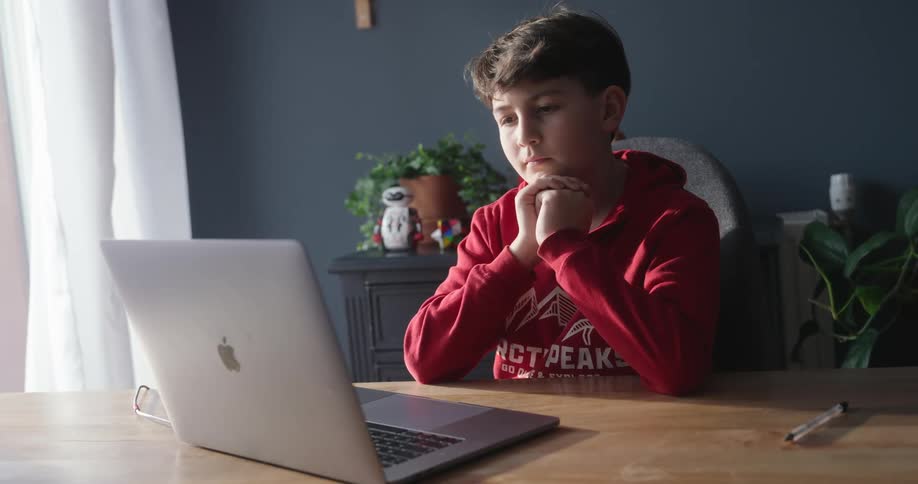 Boy sitting typing on a laptop