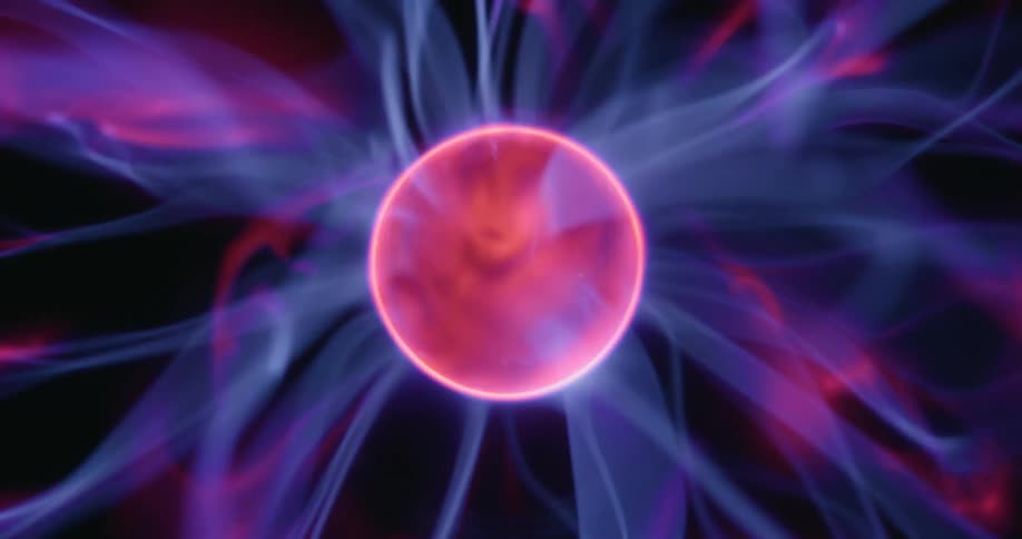 A stationary plasma orb spins rapidly at its center as neon arcs shoot out in every direction illuminating the dark background with intense bursts of shifting color and energy