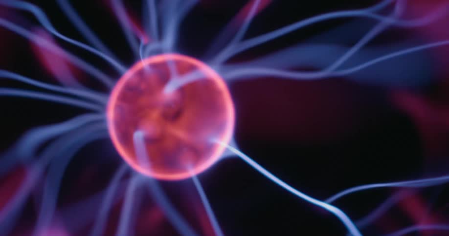 Within a plasma globe bright beams shoot from a moving center orb flickering in swirling arcs of purple and pink against a dark backdrop capturing a mesmerizing display of electric energy