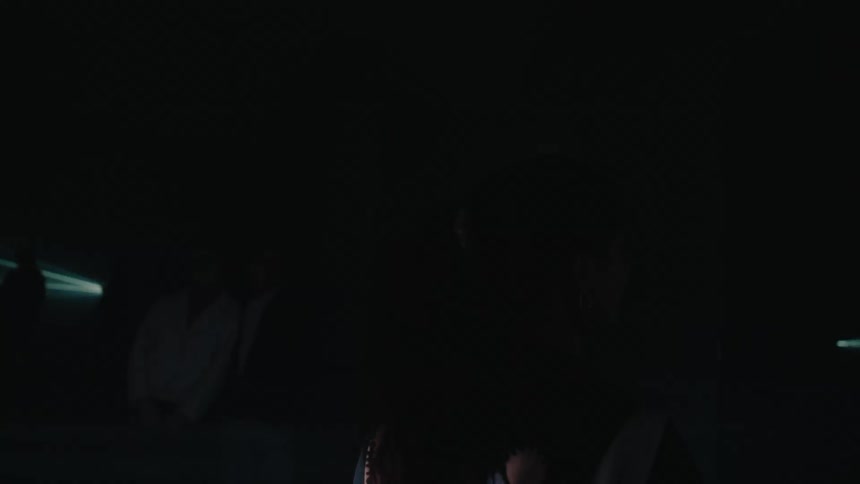 A woman walks in the pitch black room