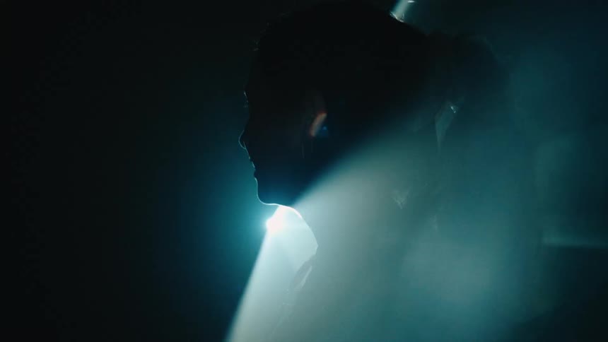 Woman walking in a dark room with studio lighting