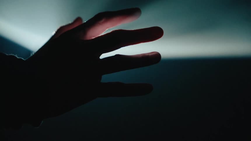 Close up of a hand silhouette against a light