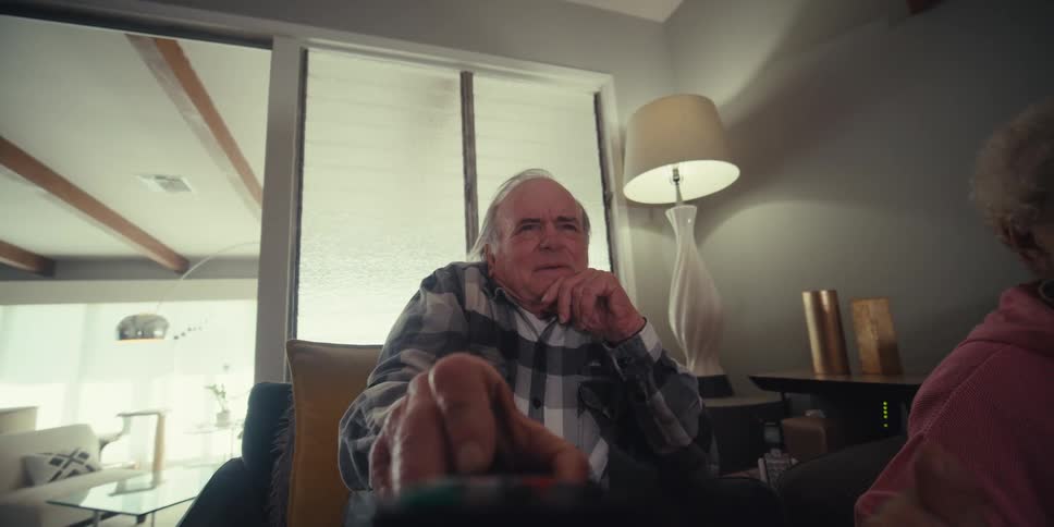 A woman passes a man the remote control
