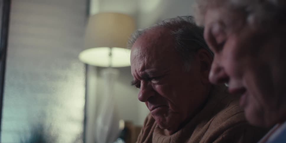 An elderly couple having a conversation in their living room