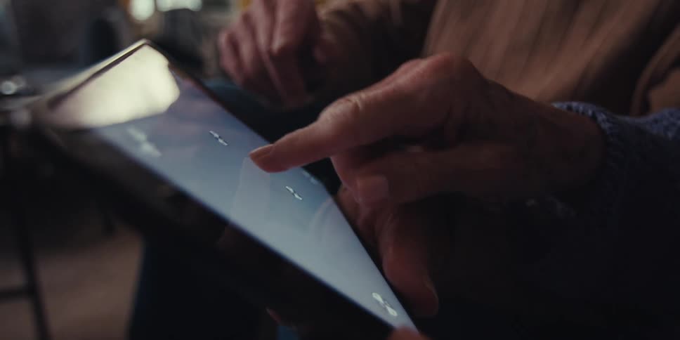A woman slides her finger across the tablet screen
