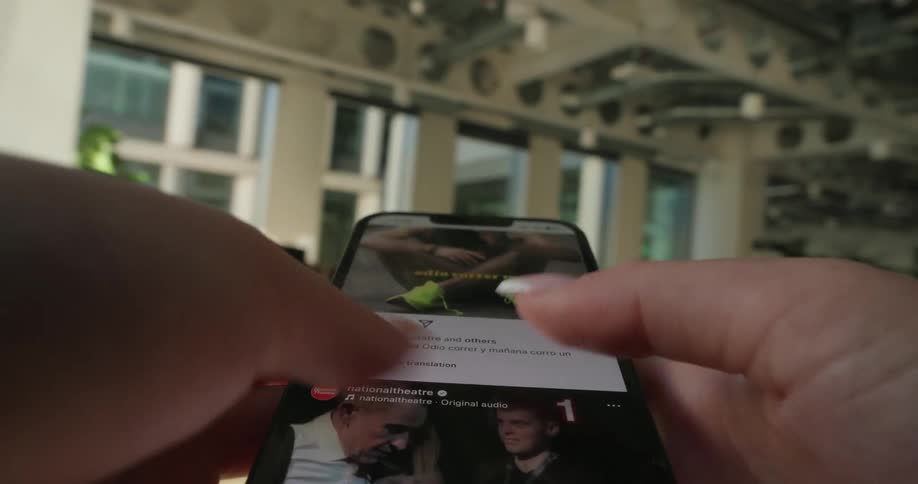 A woman is scrolling through a feed on her phone