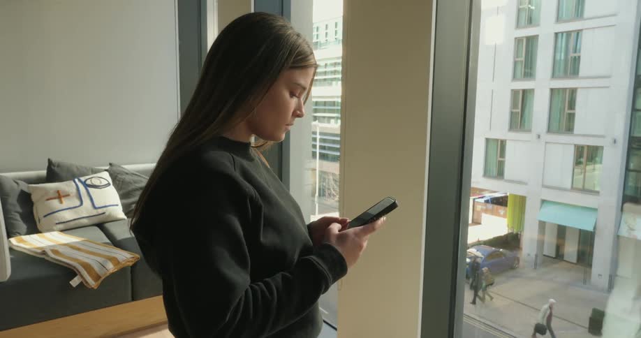 Woman typing with both hands on a smartphone screen