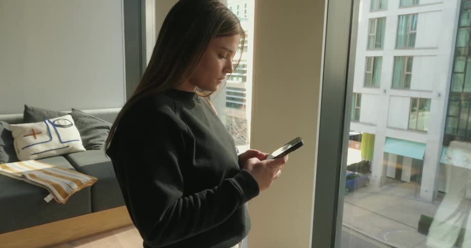 Woman standing typing on smartphone