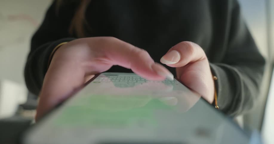 Pair of womans hands typing on a smartphone screen