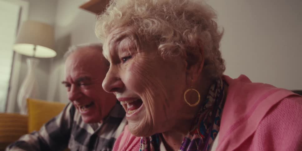Elderly couple sitting and making happy hand sign