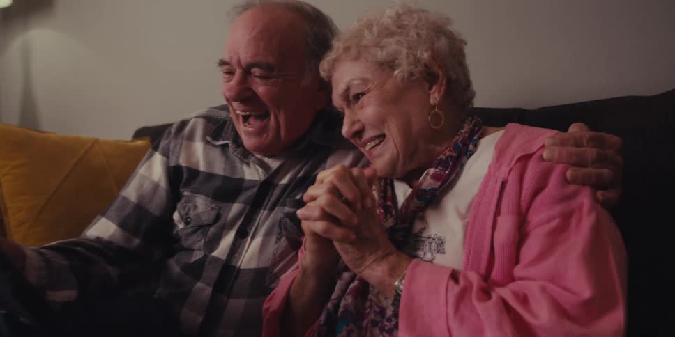 A man and woman talk on the tablet together