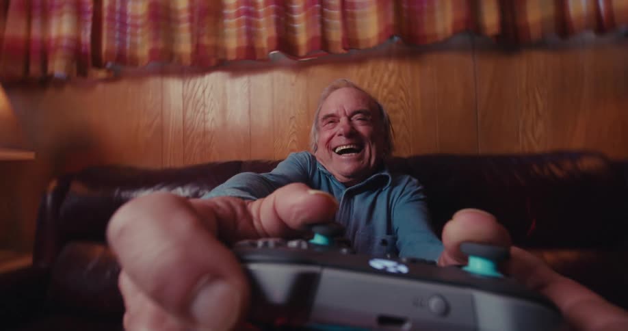 Elderly man laughing and having fun playing video games