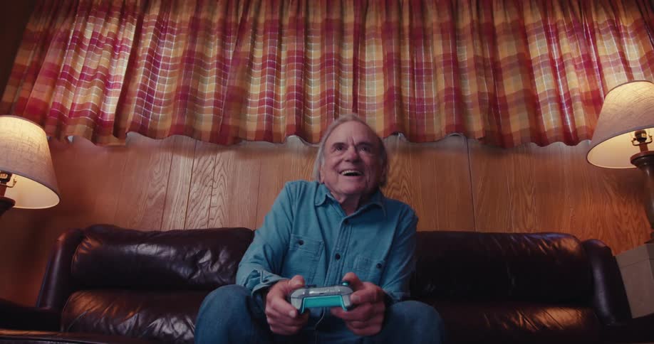 A man is sitting on the couch playing video game