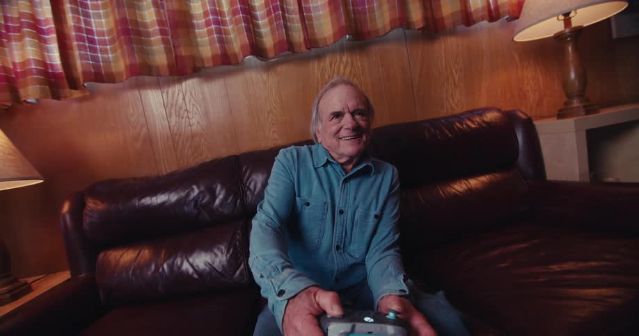 A man is laughing as he plays video games