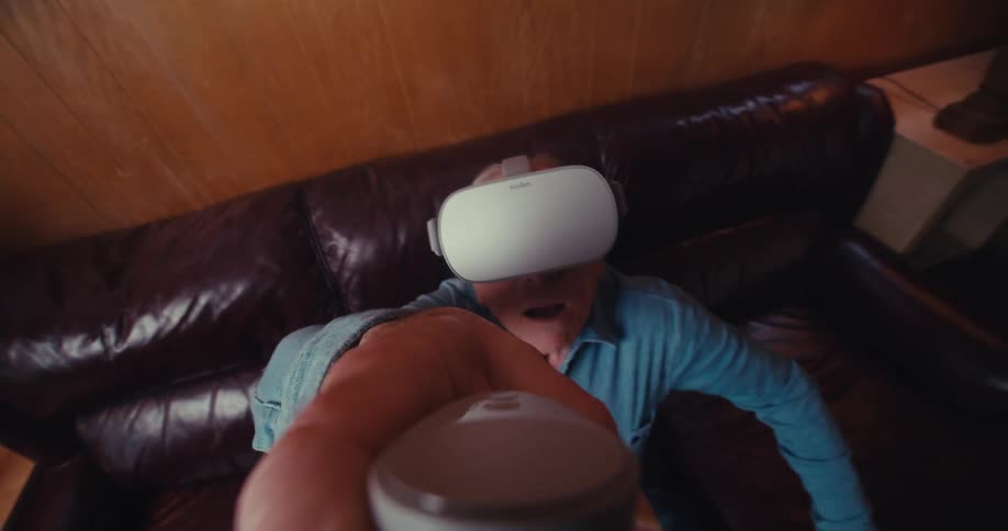 Elderly man sitting on the couch having fun using virtual reality glasses