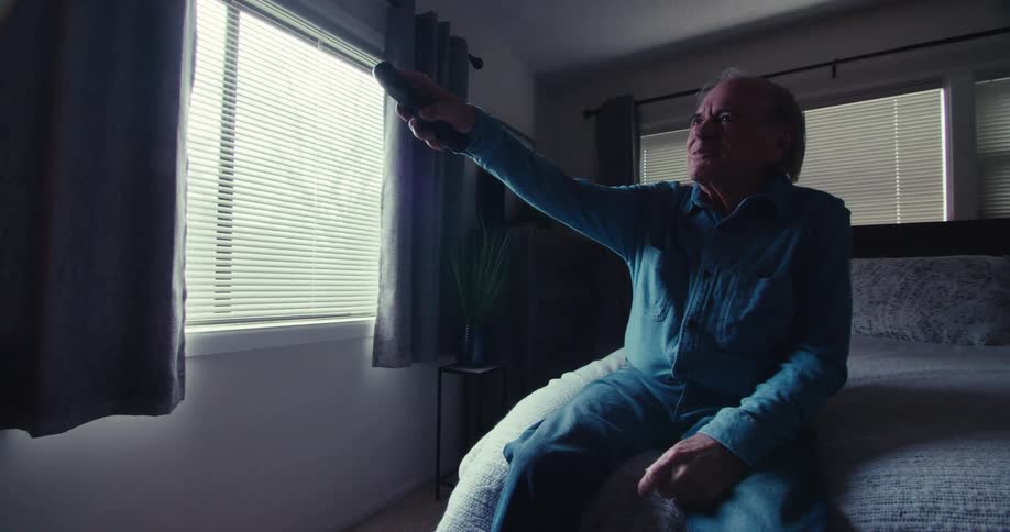 A footage of an elderly man operating a remote