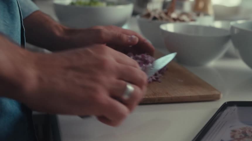 A man is cooking from a recipe on the tablet
