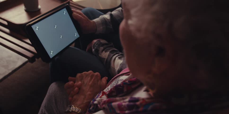 Two people sitting looking at a tablet that has a completely gray screen