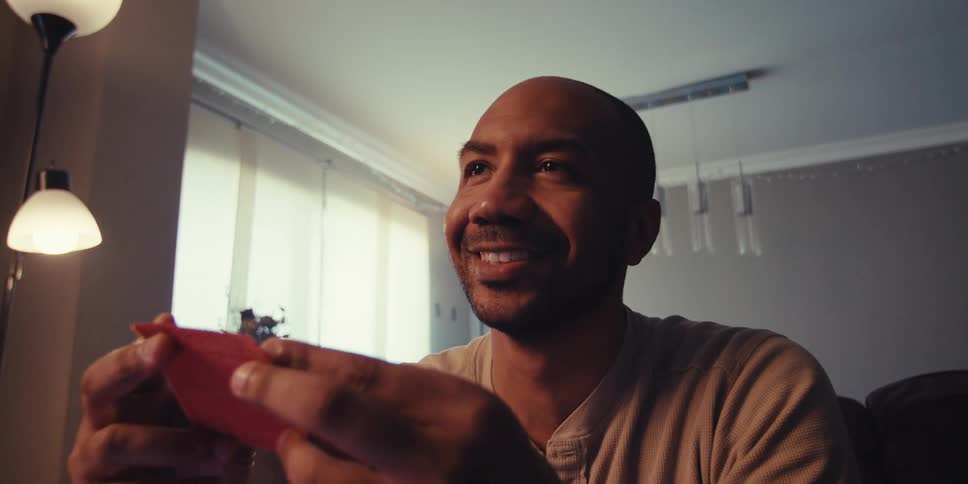 A man smiling at a card in his hand