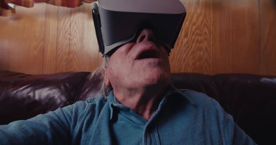 Elderly man in awe saying wow wow wearing virtual reality goggles