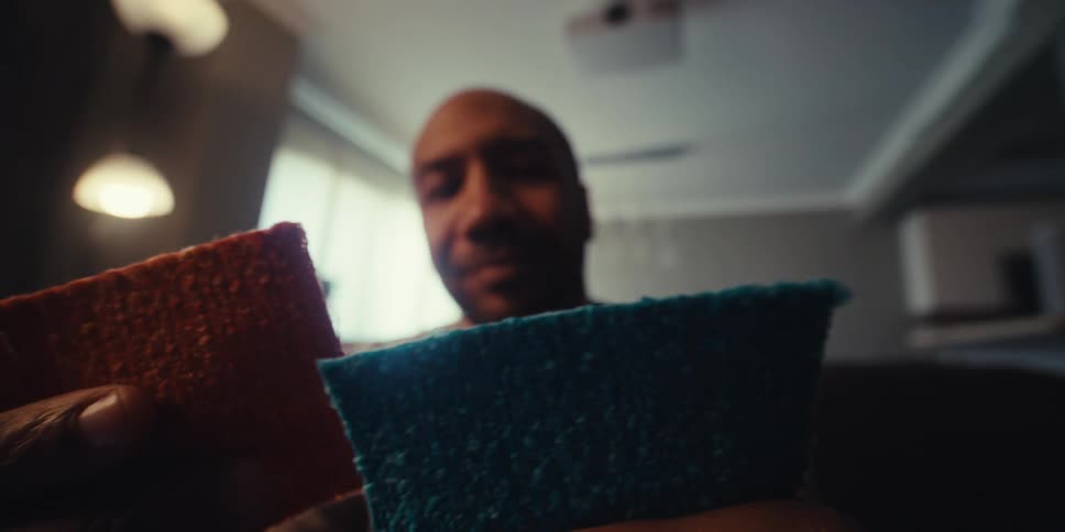 Man holding two small papers one blue and one orange