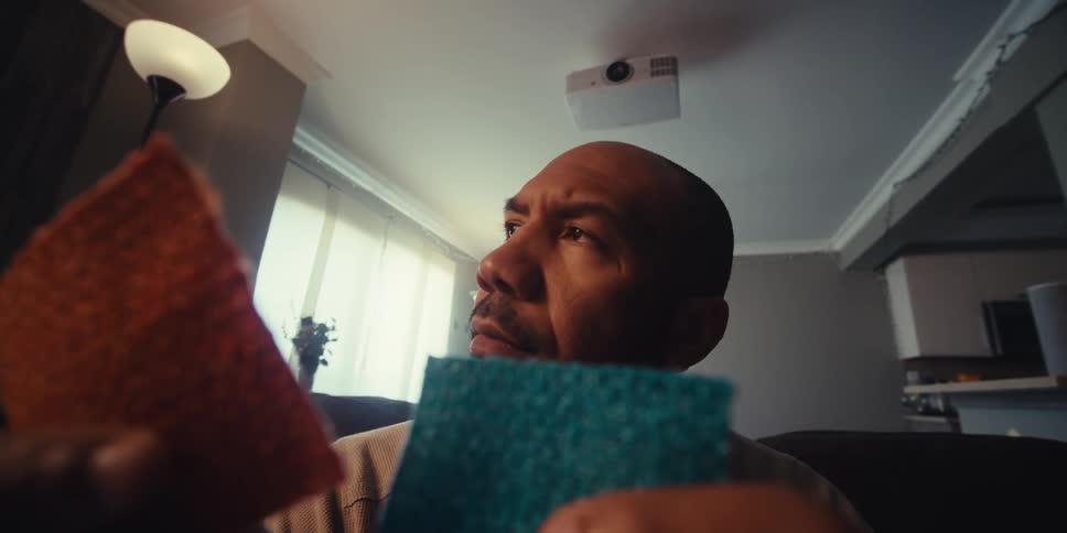 Man holding two small cloths one blue and the other red