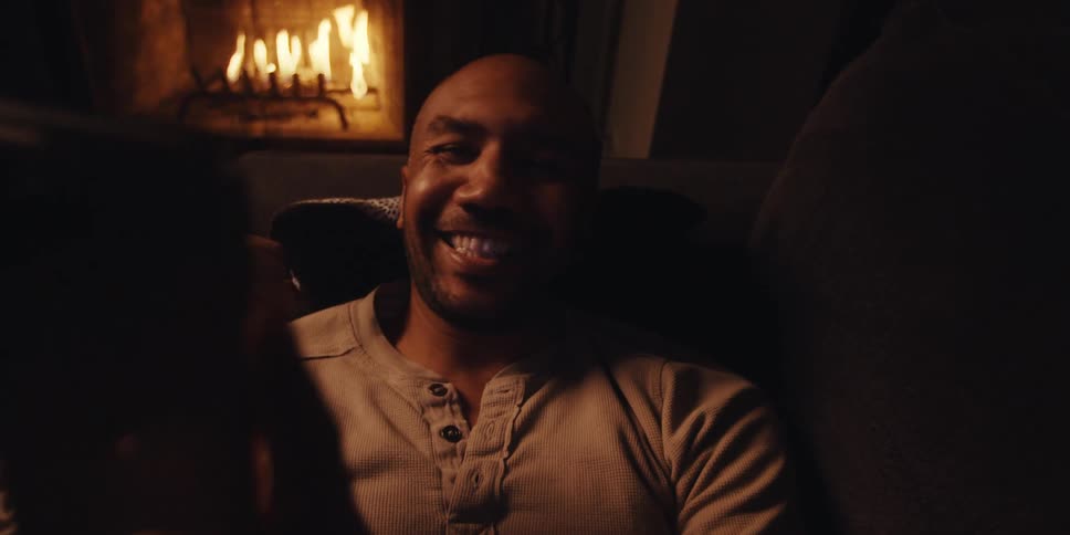 A footage of a happy man holding a smartphone indoor