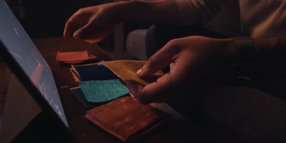 A man is trying to choose from many different types of fabric squares