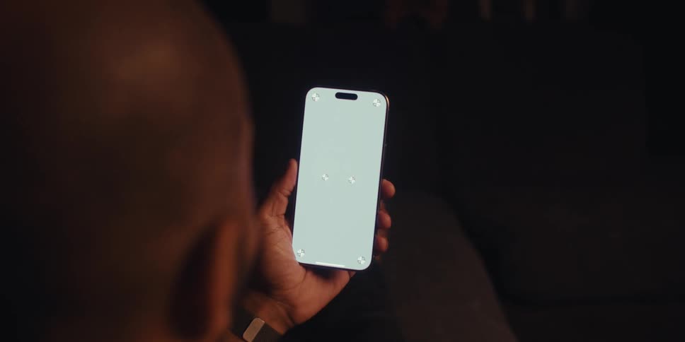 A man waves his hand at his cell phone