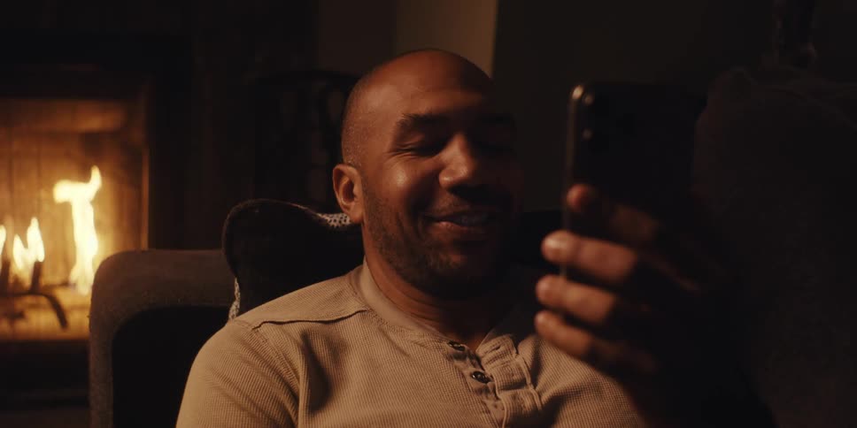 A man waves to his cell phone on a call