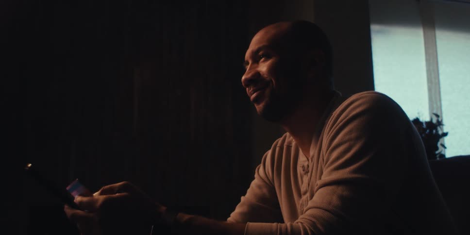 A man smiles as he puts his credit card into the tablet