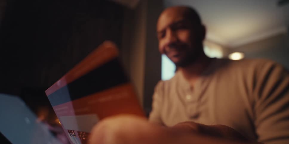 The man smiles as he puts his credit card information into the tablet