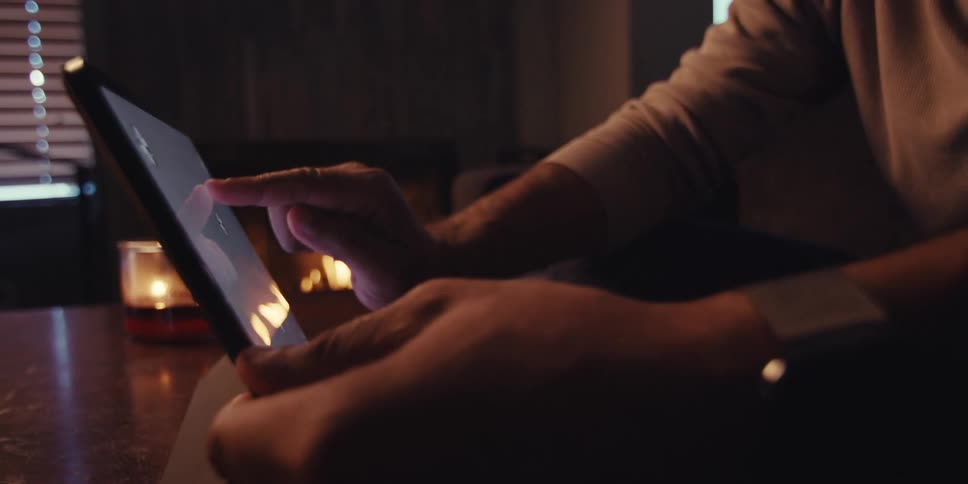 Two people sitting looking at a tablet that has a completely gray screen