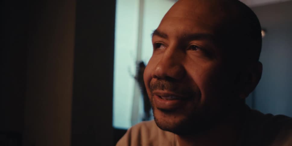 A man smiles in the dark room
