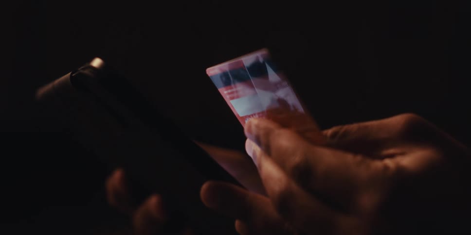 Close up of a persons hands holding a tablet and a credit card