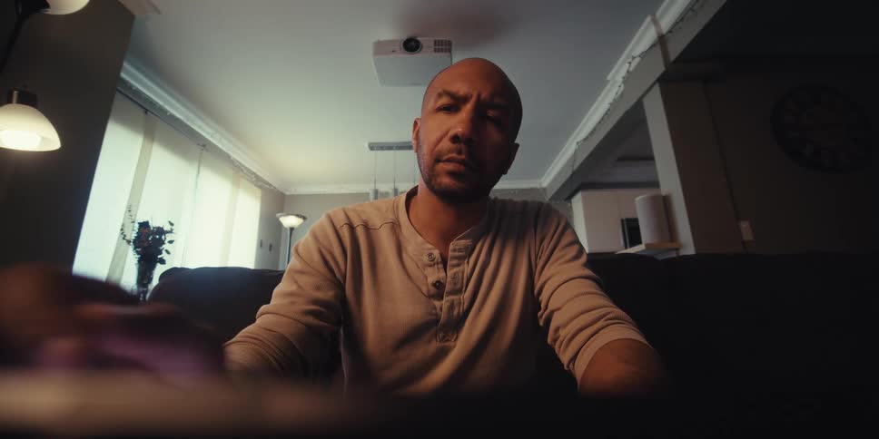 Man sitting in living room interacting with a device