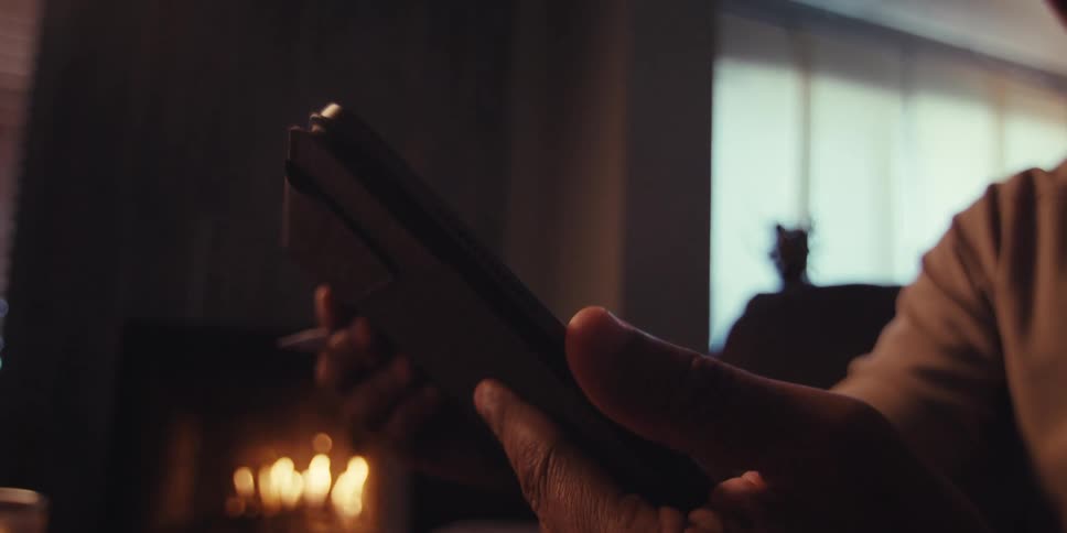 A man types on his tablet as he sits near a fire