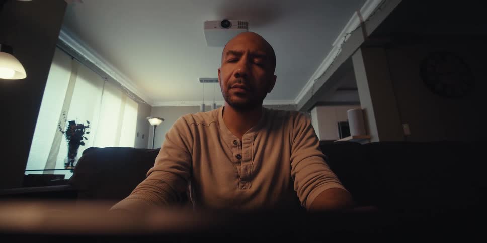 Man typing something into his tablet and then sitting better in the sofa