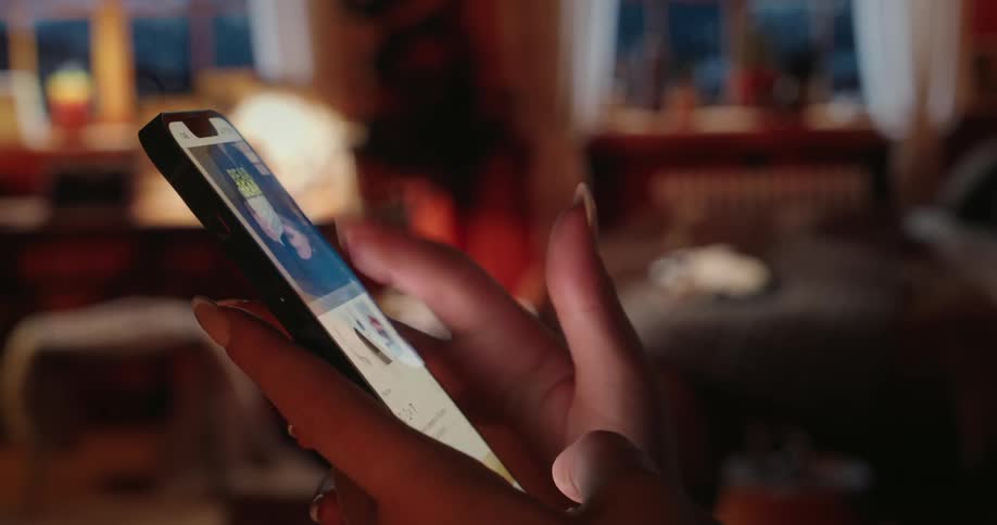 Hands of a girl on the side scrolling a cell phone