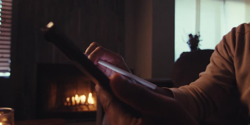 Hands holding a digital pen and interacting with a tablet