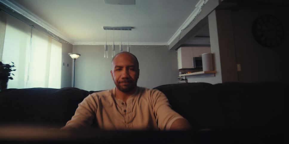 Portrait of a man in a living room holding an object