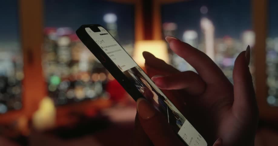 A woman is scrolling through images on her phone